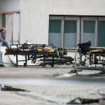 Un trabajador traslada una cama quemada en un incendio en la ciudad de Tetovo, en Macedonia