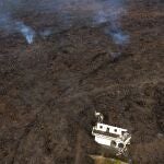 La lava de la erupción de un volcán fluye destruyendo casas en la isla de La Palma