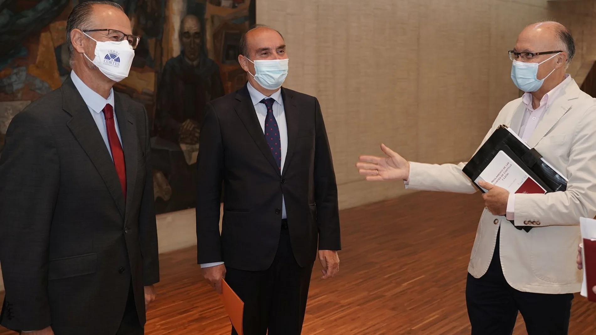 El procurador del Común, Tomás Quintana, conversa con el presidente de las Cortes, Luis Fuentes, y el parlamentario Ramiro Ruiz Medrano, antes de presentar la Memoria de Transparencia de 2020