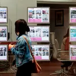 Una persona pasa ante el escaparate de una agencia inmobiliaria