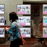 Una persona pasa ante el escaparate de una agencia inmobiliaria