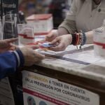Una persona recoge una mascarilla de una de las 2.882 farmacias madrileñas