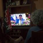 AME8002. MANAGUA (NICARAGUA), 04/10/2021.- Dos mujeres observan el discurso del presidente Daniel Ortega hoy en Managua (Nicaragua). El gobernante frente sandinista de liberación nacional (FSLN), da por iniciada formalmente su campaña de cara a los comicios generales del 7 de noviembre próximo. EFE/Jorge Torres
