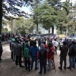 Indigenous men stand in a circle as they provide security for their group inside the National Park of Bogota, where hundreds have been camped out for about one week, in Colombia, Thursday, Oct. 7, 2021. Indigenous people from different parts of the country are waiting for the government to guarantee their safe return home, to villages they left behind due to violence. (AP Photo/Fernando Vergara)