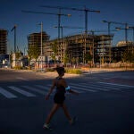 Una mujer pasa por delante de varios edificios en construcción