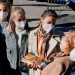 La reina Letizia (c), la princesa Leonor (2i) y la infanta Sofía (i) conversan con los habitantes de Santa María del Puerto, Asturias, en el concejo de Somiedo, reconocido como el Pueblo Ejemplar de Asturias de este año, donde han sido recibidos al son de las gaitas y con banderas de España y del Principado.