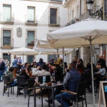 Grupos de comensales sentados en una terraza de un establecimiento