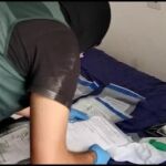 Un agenta de la Guardia Civil examaina el contenido del material que se ha incautado