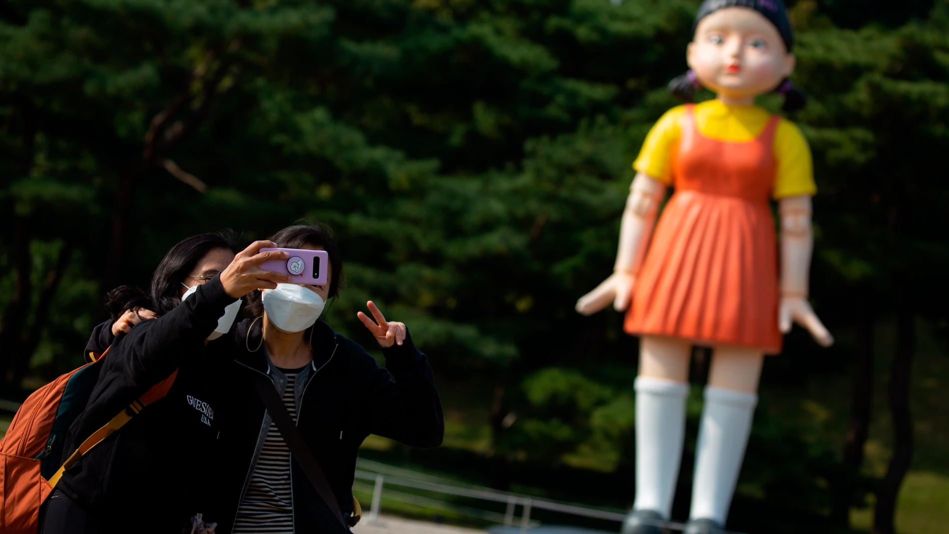 -FOTODELDIA- Seúl (Corea del Sur) 26/10/2021.- Dos jóvenes se hacen una foto frente al robot del primer capítulo de la serie 'El juego del calamar' que se erige en el Parque Olímpico de Seúl, Corea del Sur este martes. EFE/ Jeon Heon-kyun