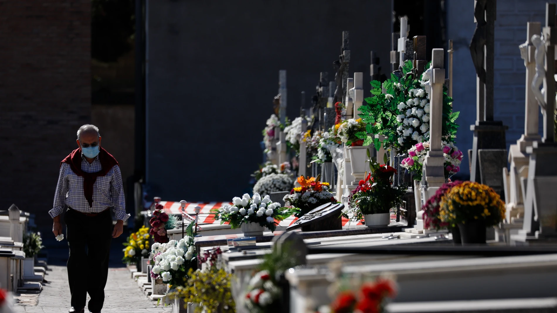 Un hombre pasea con una mascarilla en un cementerio de Murcia