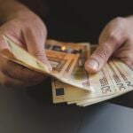 Una persona cuenta billetes de 50 euros