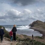 Vista de la cala de Es Freus en el municipio de Mahón, litoral norte de Menorca, donde algunos turistas se han acercado para observar el inicio de la llegada del temporal