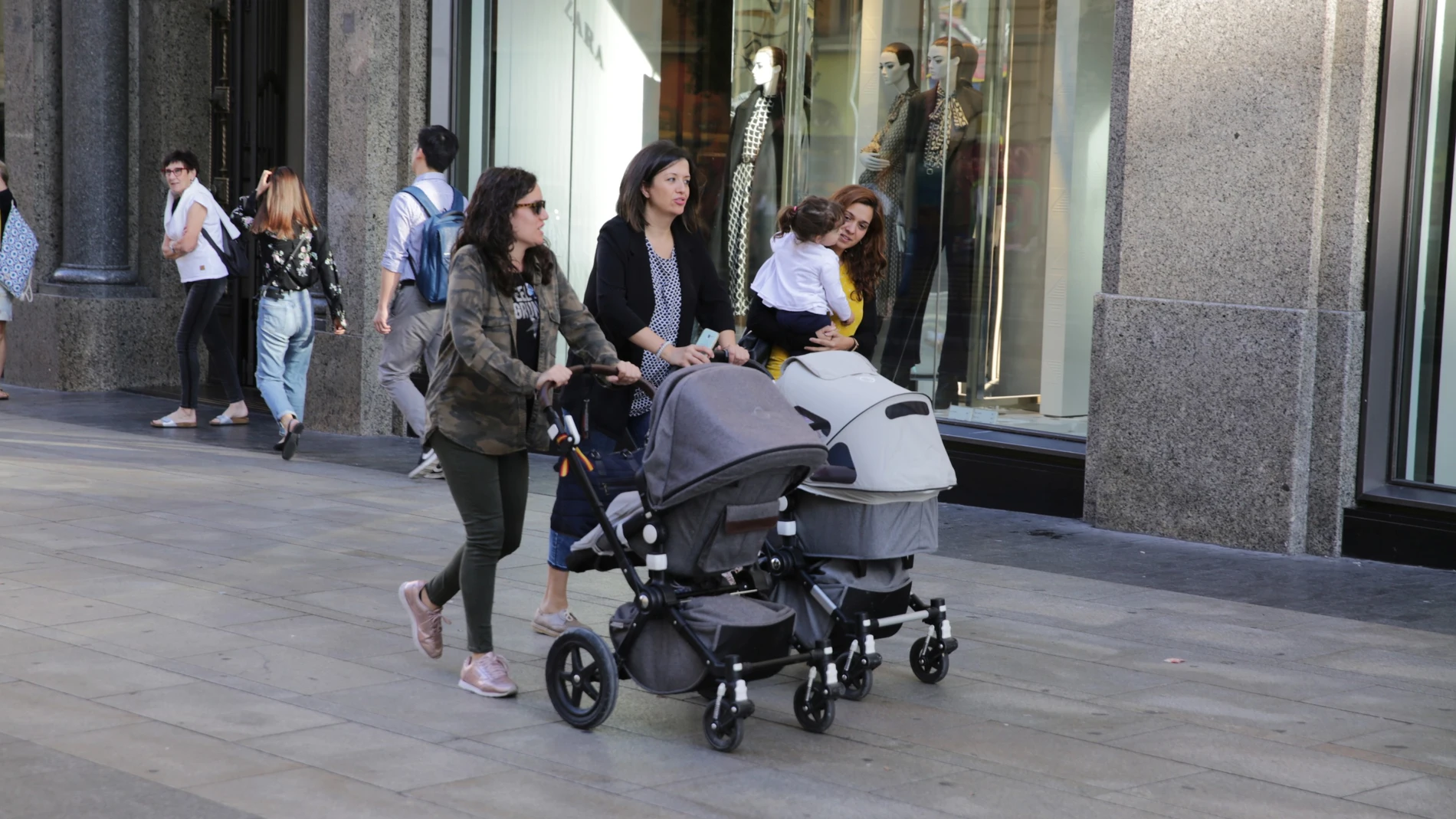 Unas madres pasean con sus bebés por las calles de Madrid