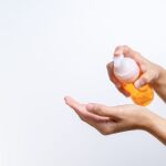 Cleaning wash essence, skin care. women hands holding cleansing bottle, beauty and body care concept