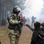Un soldado de Bielorrusia con niños refugiados en la frontera con Polonia