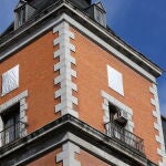 Dos de los escudos franquistas, antes de su retiro, tapados con lonas