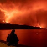 Una persona observa la lava y piroclastos a su llegada a la playa de los Guirres,