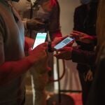 Una persona muestra un código QR para entrar a un local de ocio nocturno
