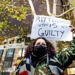 Una manifestante lleva un cartel en el que dice que Kyle Rittenhouse es culpable, el viernes en Kenosha