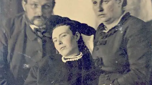 Fotografía post-mortem de una joven muerta y sus padres.
