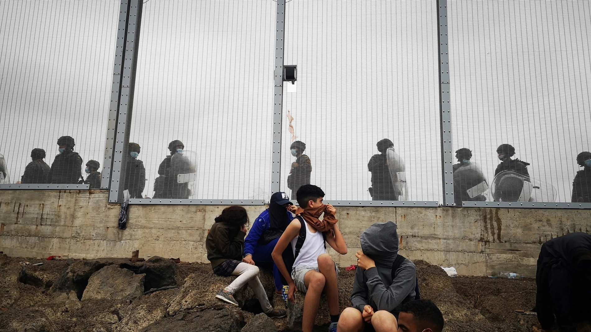 Miembros de la policía Nacional vigilan la verja que separa Ceuta de la localidad de Fnideq (Castillejos) en una avalancha de inmigrantes sin precedentes en España.