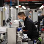 Varios operarios trabajan en la cadena de producción y montaje de una empresa