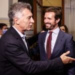 El líder del Partido Popular (PP), Pablo Casado (d), ríe mientras conversa con el expresidente argentino Mauricio Macri (i), durante una comparecencia ante la prensa en Argentina
