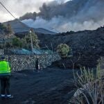 Un agente de la Guardia Civil observa la última colada del volcán de Cumbre Vieja en el camino de Tacande
