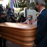 Unos operarios trasladan el féretro del tenista Manolo Santana de la capilla ardiente