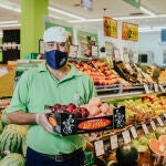 Un empleado de Grupo MAS sostiene productos frescos en uno de los establecimientos del Grupo