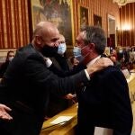 Juan Espadas saluda a Antonio Muñoz minutos antes de leer su renuncia al cargo en el Pleno extraordinario del Ayuntamiento de Sevilla. EDUARDO BRIONES/EP