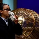 Una niña del Colegio de San Ildefonso bebe agua tras cantar el primer premio. EFE/ Juan Carlos Hidalgo