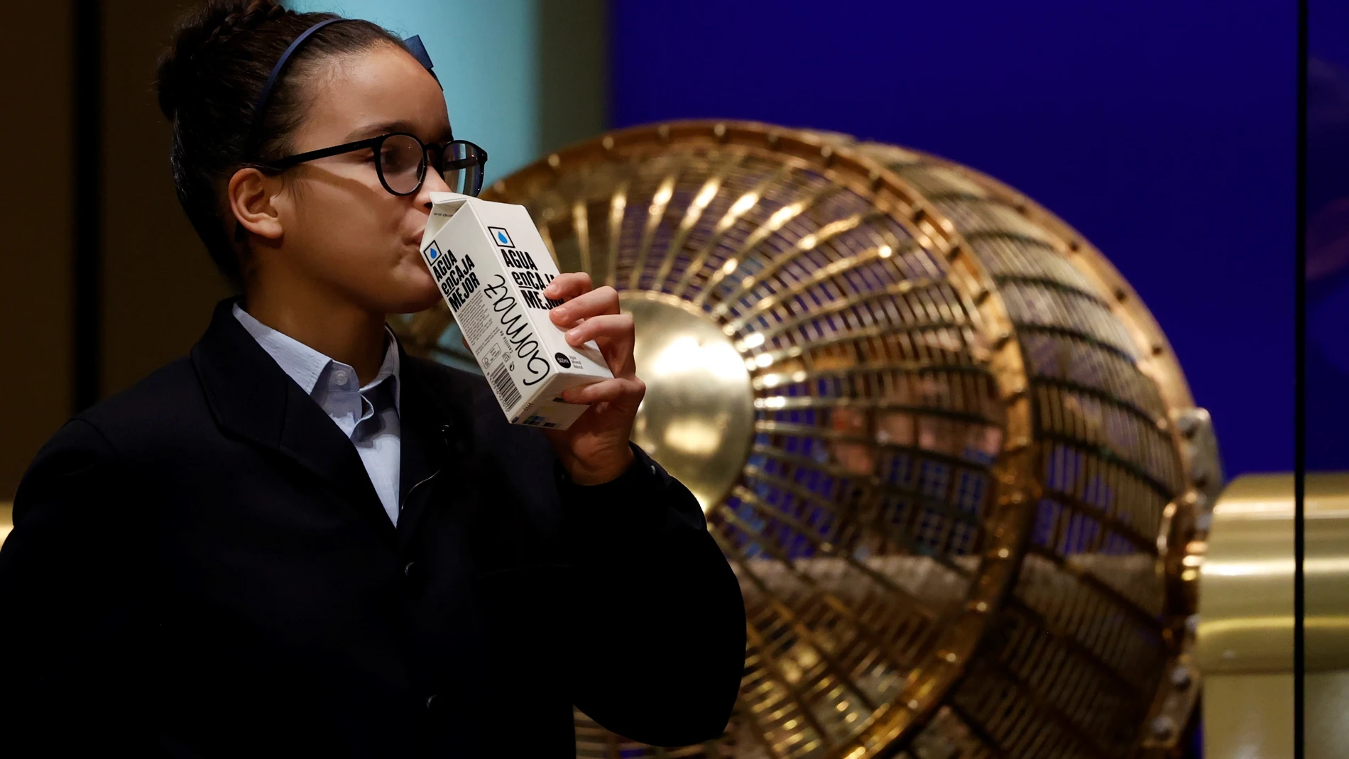Una niña del Colegio de San Ildefonso bebe agua tras cantar el primer premio. EFE/ Juan Carlos Hidalgo