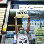 Javier Moñino, empleado de la administración situada en la zona del AVE de la Estación de Atocha, celebra que ha vendido parte del número 86148 correspondiente al 'Gordo' del Sorteo Extraordinario de la Lotería de Navidad,