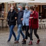 varias personas caminando con mascarillas