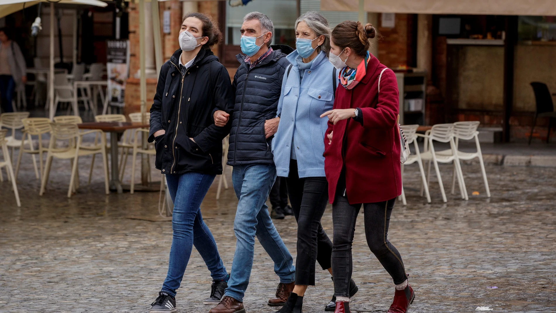 varias personas caminando con mascarillas