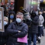 La gente espera en la fila en un sitio de pruebas de COVID-19 en Times Square de Nueva York