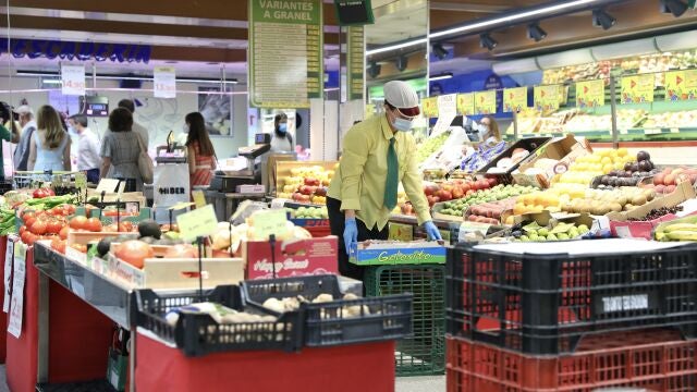 Una empleada de un supermercado trabajando en la sección de frutería