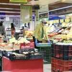 Una empleada de un supermercado trabajando en la sección de frutería