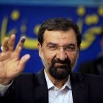 FILE - Mohsen Rezaei waves to reporters after registering as a presidential candidate, in Tehran, Iran, May 10, 2013. Argentinaâ€™s Foreign Ministry said Tuesday, Jan. 11, 2022, that the appearance of Rezaei, at the investiture of Nicaraguaâ€™s president on Monday was â€œan affront to Argentine justice and to the victims of the brutal terrorist attackâ€³. Rezaei, a former leader of Iranâ€™s paramilitary Revolutionary Guard, is wanted by Argentina on an Interpol â€œRed Noticeâ€ alleging he was involved in the 1994 bombing of a Jewish center in Buenos Aires that killed 85 people. (AP Photo/Vahid Salemi, File)