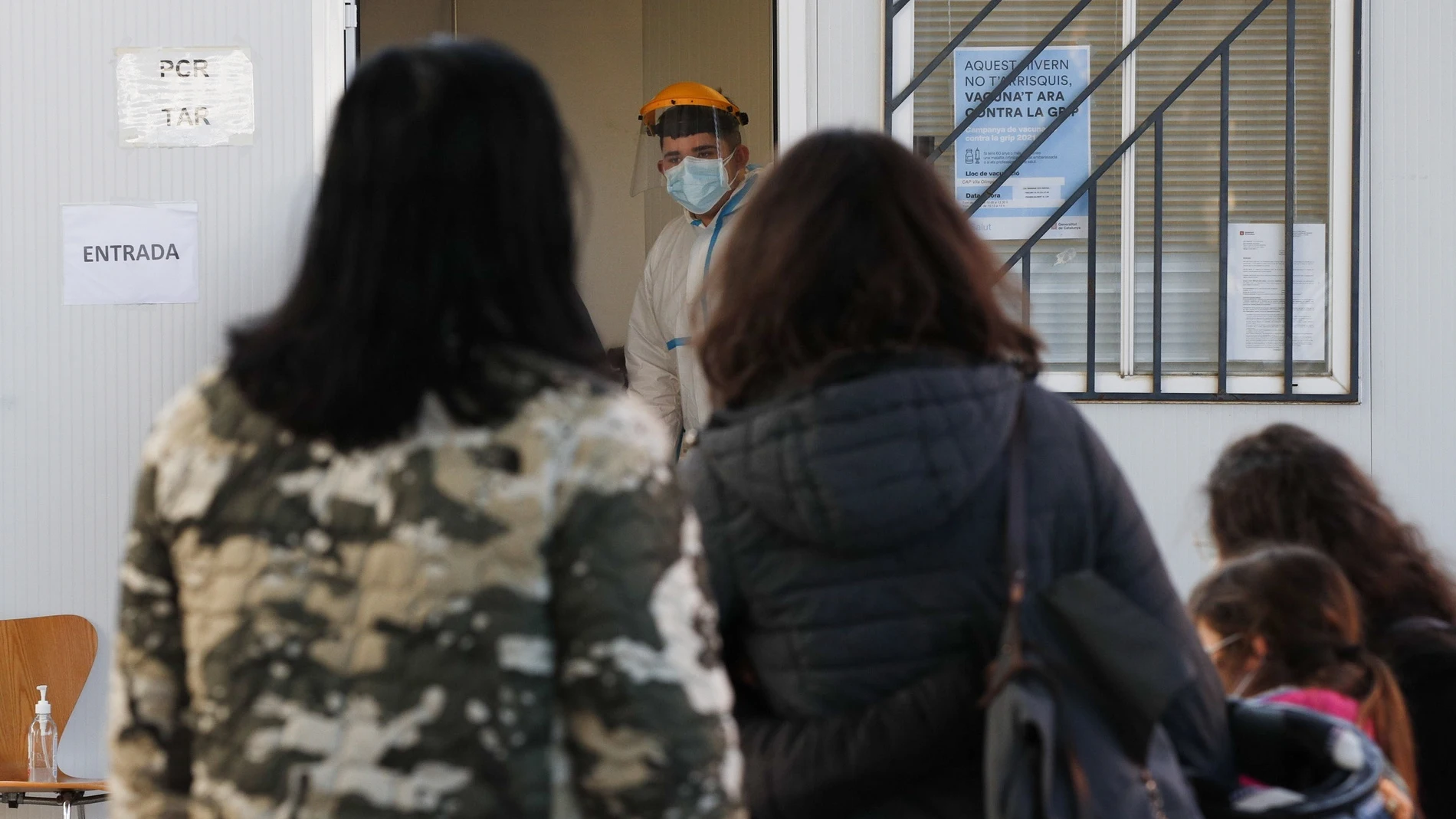 Varios padres con sus hijos esperan para realizarse TAR y PCR en el Centro de Atención Primaria de Villa Olímpica, en Barcelona este viernes, cuando Cataluña ha superado los 25.000 muertos oficiales por covid desde el inicio de la epidemia