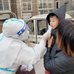 Un sanitario realiza un test a un niño en Huaxian, China