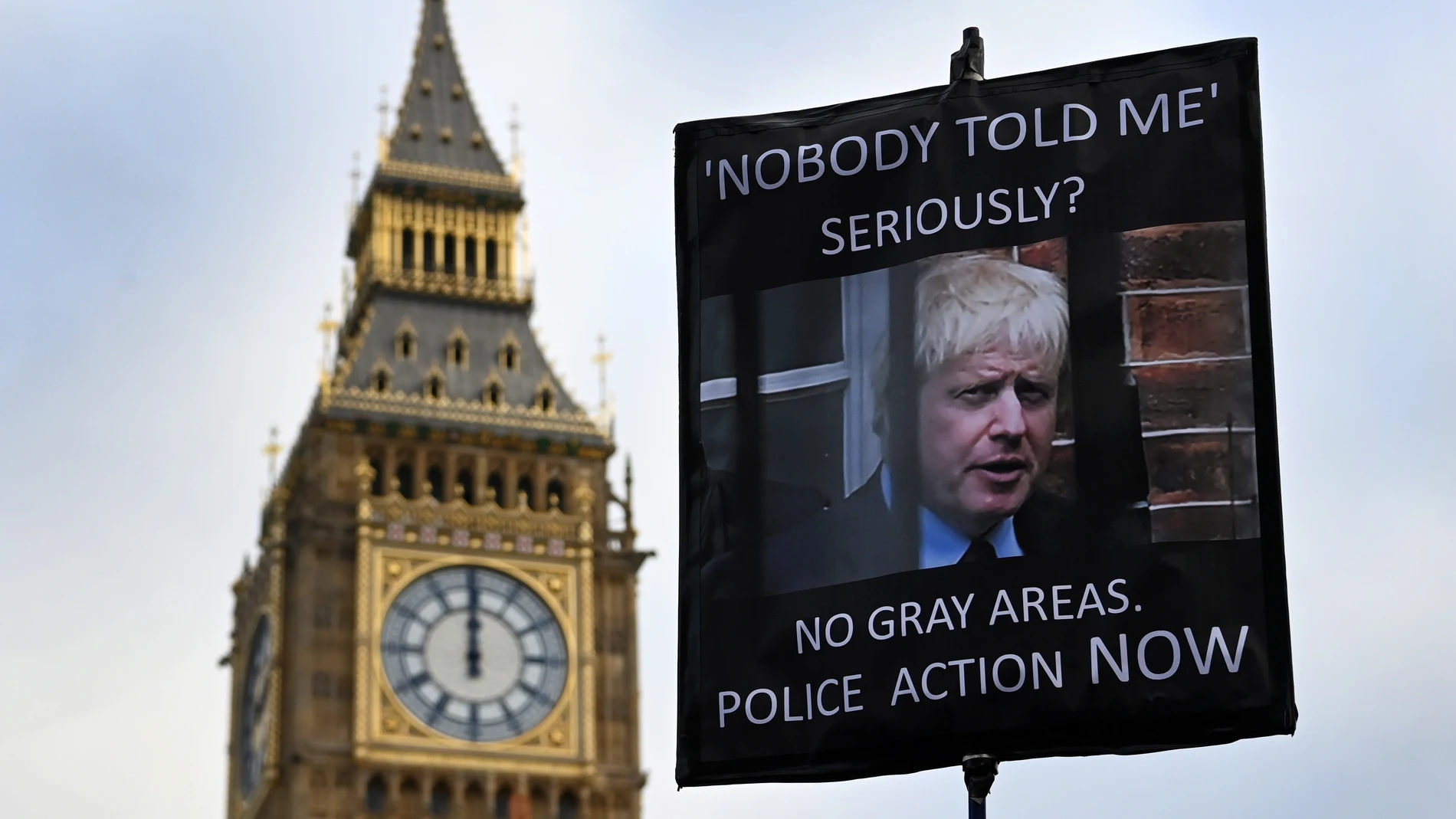 Una pancarta reclama que la Policía investigue a Boris Johnson por el «Partygate» durante una protesta frente al Parlamento