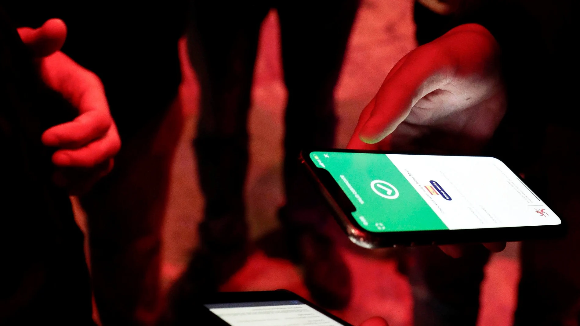 Una persona comprueba el pasaporte covid a la entrada de un local de ocio