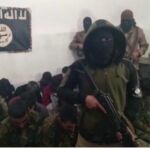 Un miembro del Estado Islamico habla a la cámara delate de los militares del PKK apresados