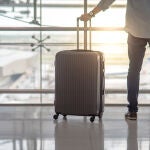 Un hombre lleva una maleta de mano en un aeropuerto
