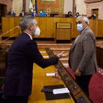 El consejero de Hacienda, Juan Bravo,(i) habla con el parlamentario Ramírez de Arellano, (d) durante la Sesión Plenaria Extraordinaria el Parlamento de Andalucía. Joaquín Corchero / Europa Press
