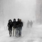 Varias personas caminan por las calles de Boston, donde el manto de nieve registró hasta 60 centímetros de altura