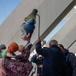 Varios trabajadores llevan un ninot a la exposición del Ninot de las Fallas 2022, en el Museo de las Ciencias Príncipe Felipe