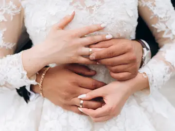 El novio y la novia se están poniendo anillos de boda, vista frontal de las manos El novio y la novia se están poniendo anillos de boda, vista frontal de las manos